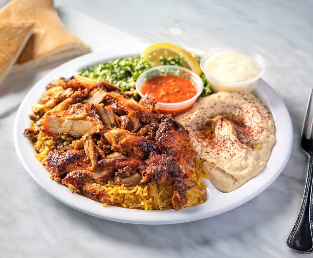 Mediterranean Chicken Shawarma Dinner from Sultan’s Market – marinated spit roasted boneless chicken served with hummus, rice, tabuli salad and a warm pita for a balanced, heart-healthy meal.