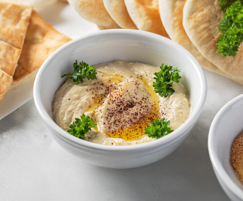 A vegan, gluten-free hummus topped with olive oil and served with pita from Sultan's Market, a Middle Eastern restaurant in Chicago